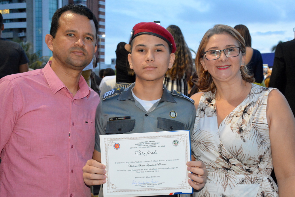 Vinicius Ryan e seus pais com o certificado de aluno nota 10